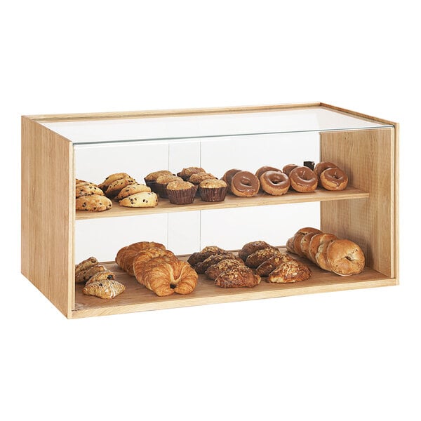 A Cal-Mil wooden 2-tier bakery display case with pastries and breads.