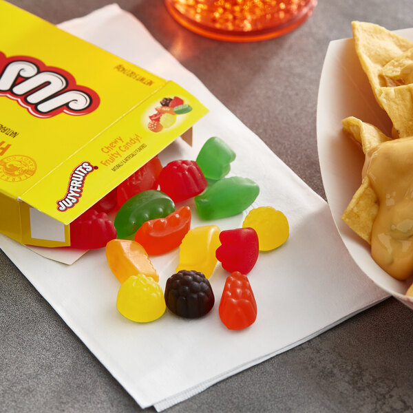 A plate of Jujyfruits next to a box of Jujyfruits.