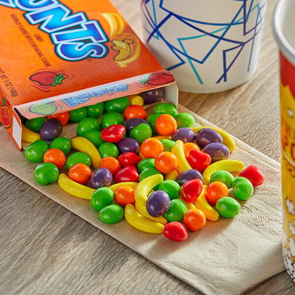 A box of Runts candy on a table with a cup of coffee.