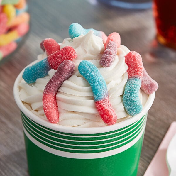 A cup of ice cream with Trolli Very Berry Sour Brite Gummy Crawlers on top.