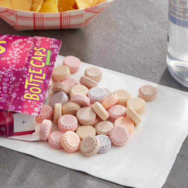 A white round Bottle Caps candy box on a table.