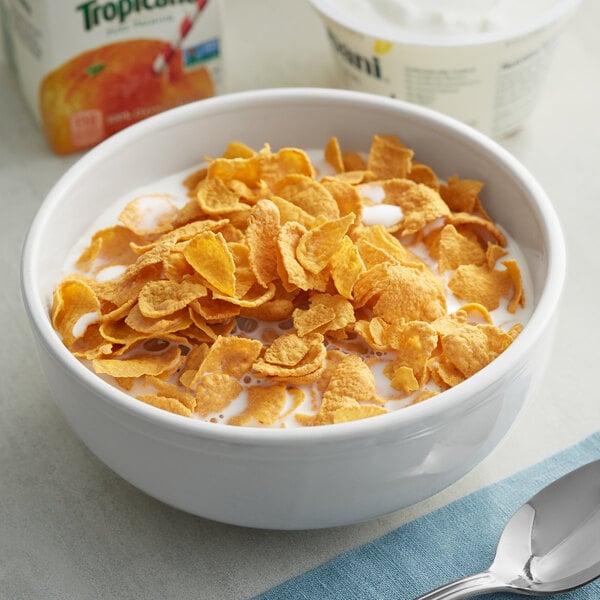 A bowl of General Mills Country Corn Flakes cereal with milk and a spoon.