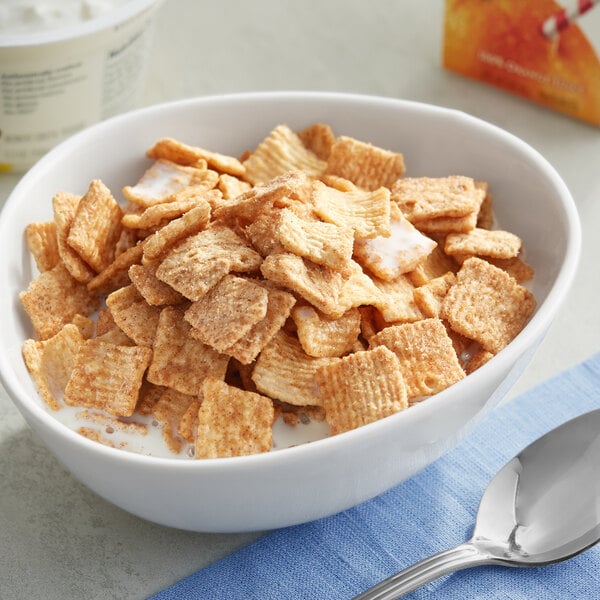 A bowl of Cinnamon Toast Crunch cereal with milk and a spoon.