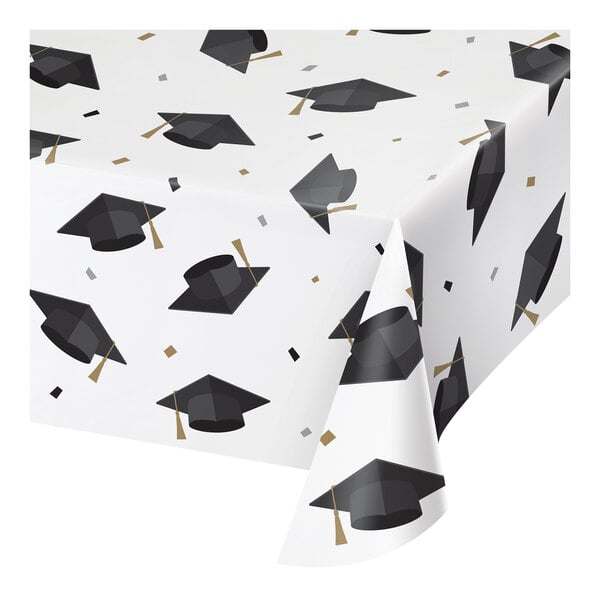 A white paper tablecloth with black and white graduation caps on it.