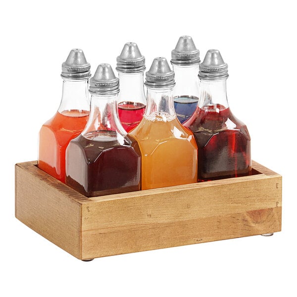 A wooden tray with six Cal-Mil Madera clear glass bitters bottles in a wooden box.