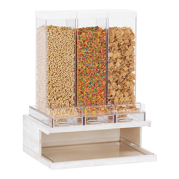 A group of cereals in a Cal-Mil white-washed pine wood triple cereal dispenser.