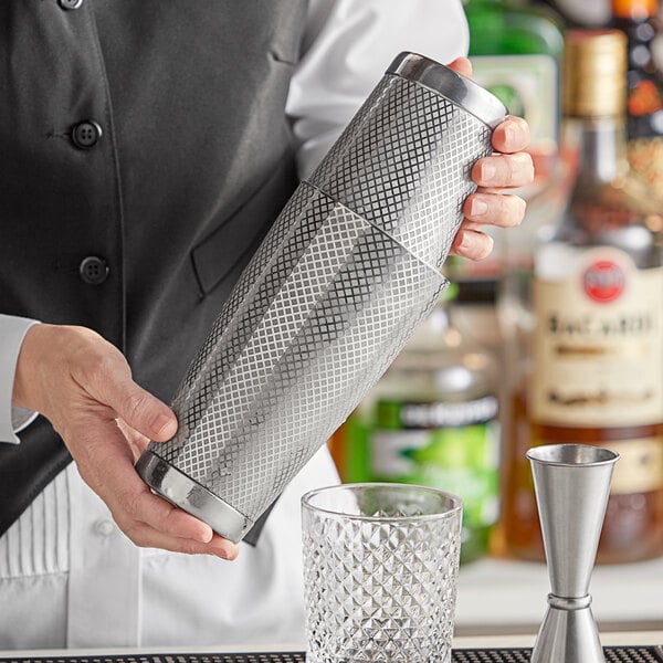 A bartender using a Barfly stainless steel cocktail shaker.