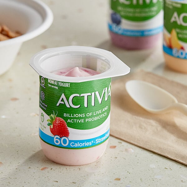 A close-up of a small Dannon Activia yogurt container with fruit.