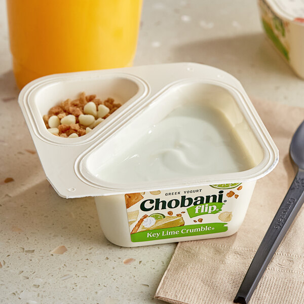 A white Chobani Flip Key Lime Crumble yogurt container with food in it next to a spoon.