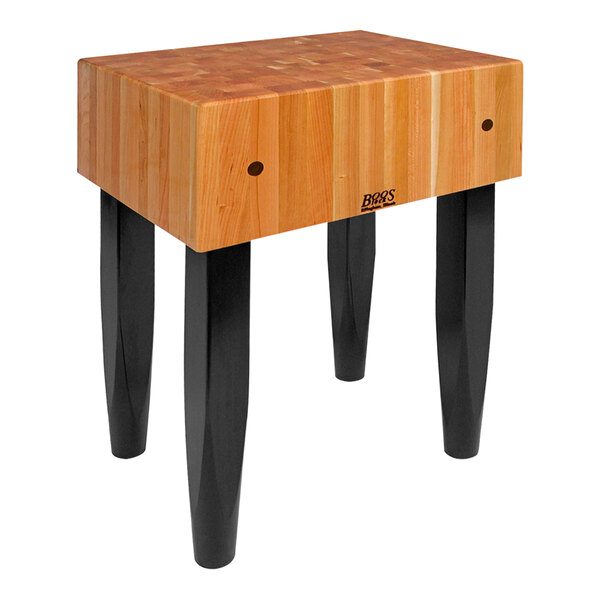 A John Boos black cherry butcher block table with two legs.