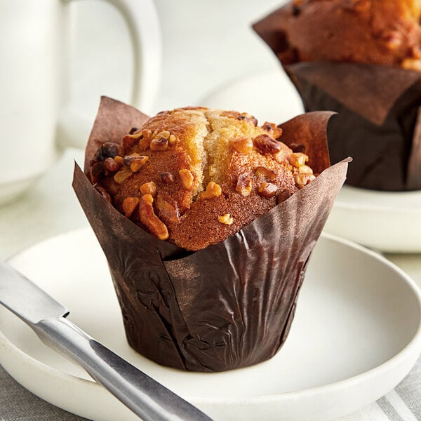An Otis Spunkmeyer banana bread muffin with nuts on a plate.