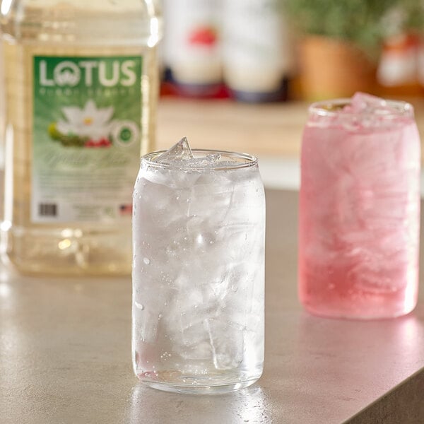 A clear glass with ice and Lotus Plant Energy White Lotus Energy Concentrate next to it.
