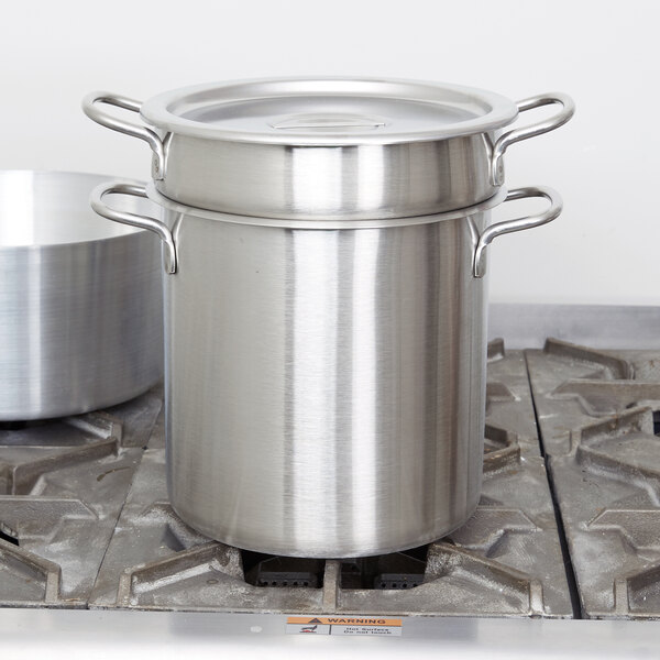 A Vollrath stainless steel double boiler set on a stove.