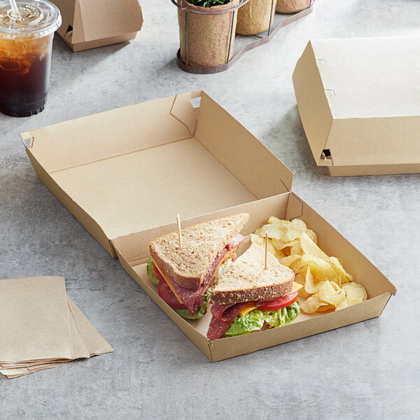 A sandwich and chips in a Sabert paper take-out box.