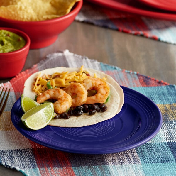 A Tuxton Concentrix cobalt blue plate with shrimp and cheese tacos.