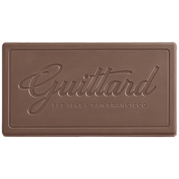 A close-up of a Guittard Heritage milk chocolate bar with the word "Guittard" on the bar.