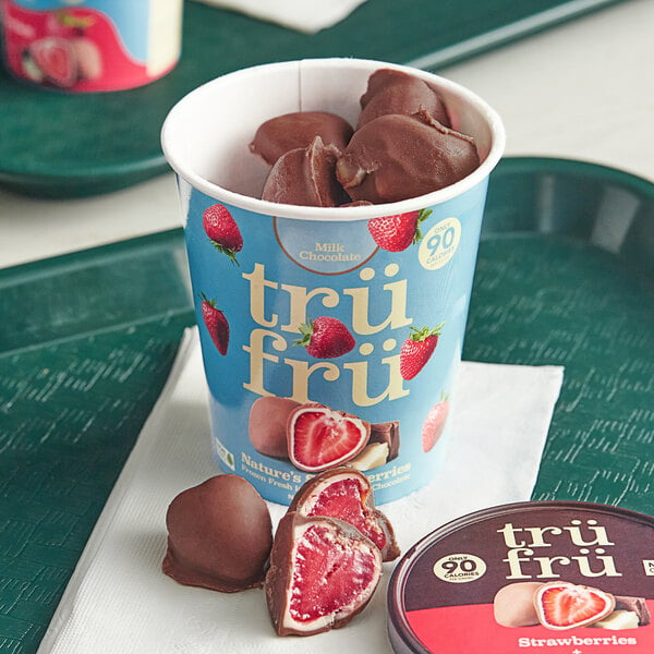 A cup of TruFru frozen white and milk chocolate covered strawberries.