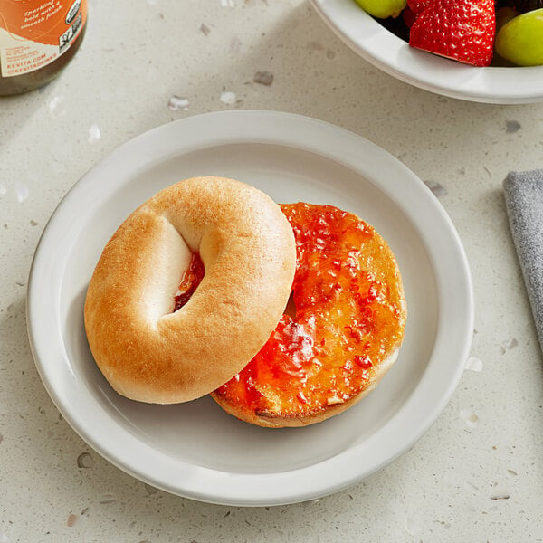 A Lender's plain bagel with jam on a plate.