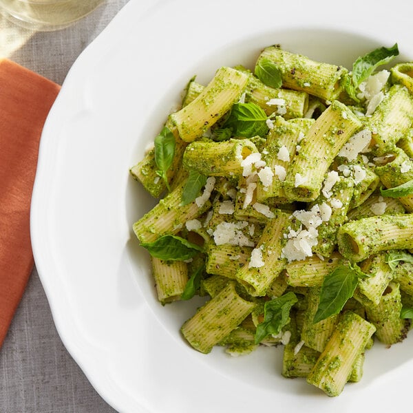 A white plate of pasta with Armanino Basil Pesto sauce and cheese.