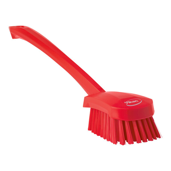 A red Vikan washing brush with a long handle.