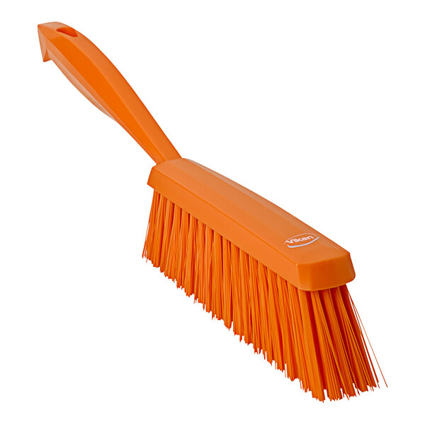 An orange Vikan medium hand brush with a handle.