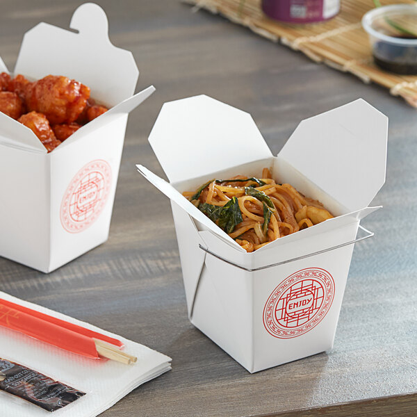 Two Emperor's Select Asian paper take-out containers with noodles and meatballs.