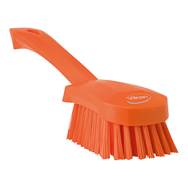 A close up of a Vikan orange washing brush with a handle.
