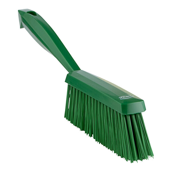 A green Vikan hand brush with a long handle.