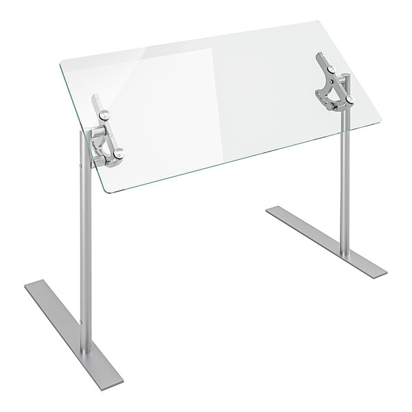 A Spring USA glass food shield with silver metal legs on a glass table.