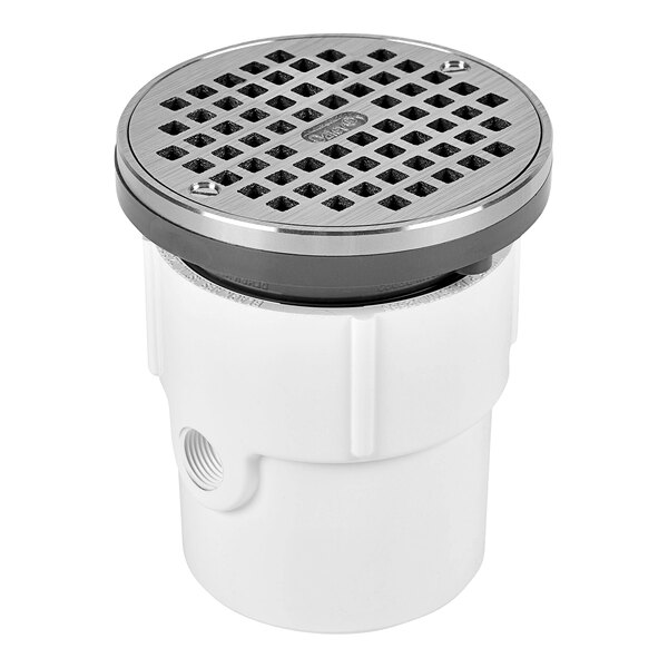 A white plastic Oatey floor drain with a round silver metal strainer.