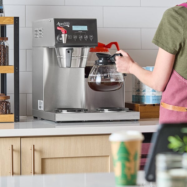 An automatic coffee maker with three lower decanter warmers on a countertop.