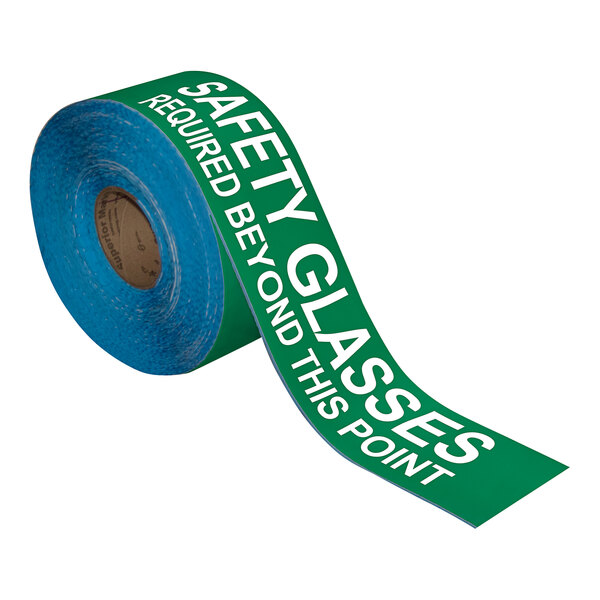 A roll of green and white Superior Mark Safety Glasses Required safety tape.