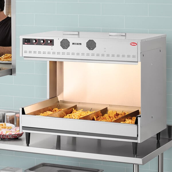 A Hatco freestanding multi-product warming station with trays of food.