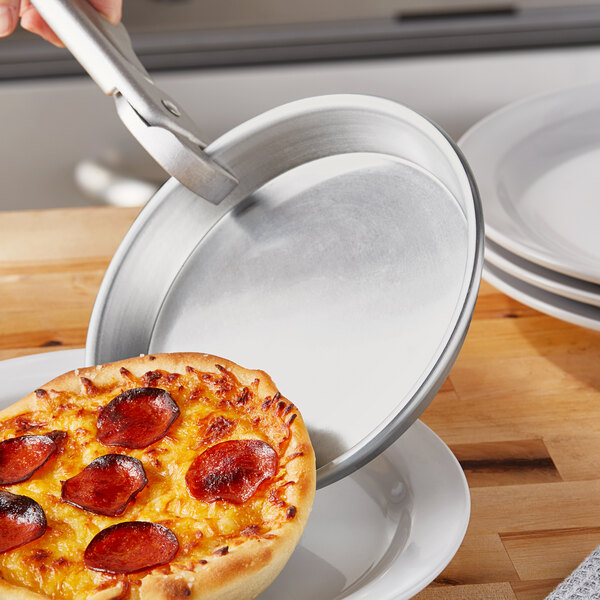 A pepperoni pizza being cut on a Choice aluminum deep dish pizza pan.