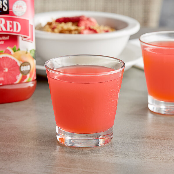 Two glasses of Langers Ruby Red Grapefruit juice on a table.