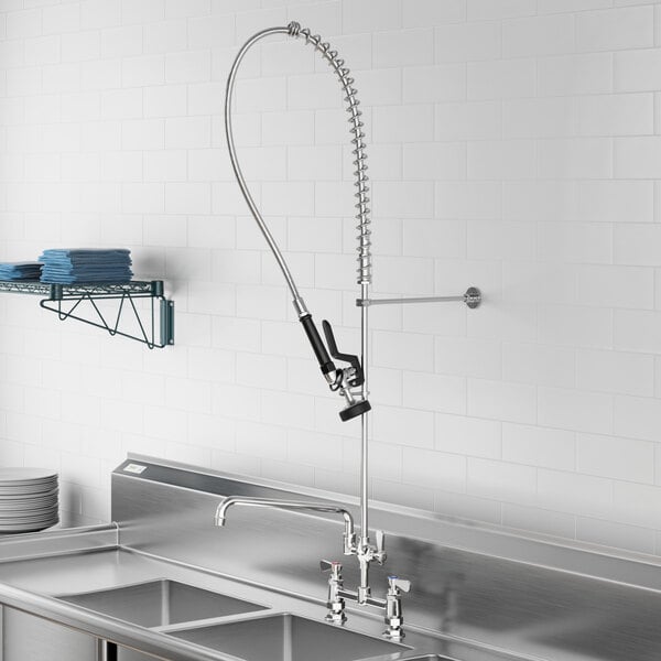 A Regency pre-rinse faucet with an add-on faucet and a hose above a stainless steel sink.