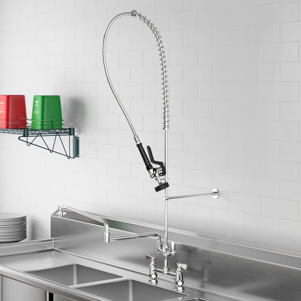 A stainless steel sink with a Regency pre-rinse faucet and double-jointed add-on faucet over it.