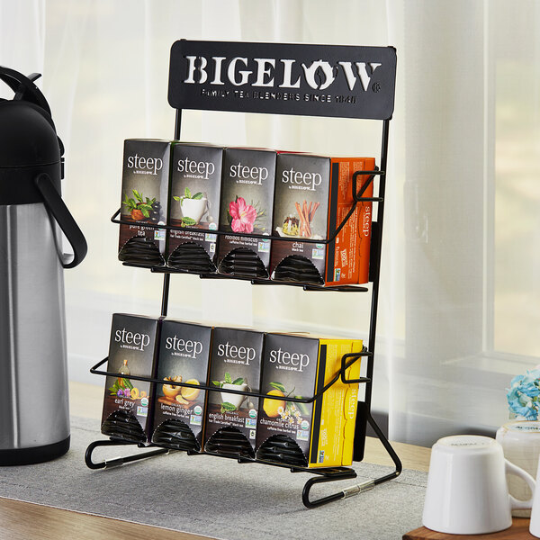 A black metal Bigelow tea rack on a table with boxes of tea.