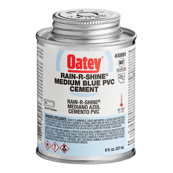 A can of Oatey medium blue cement with a label and a cap.