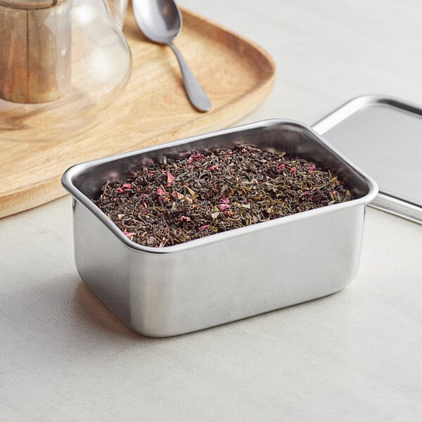 A Matfer Bourgeat stainless steel Japanese mini container filled with a mixture of leaves and a spoon.