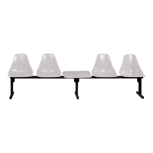 A row of three white Sol-O-Matic chairs with black legs and a table.