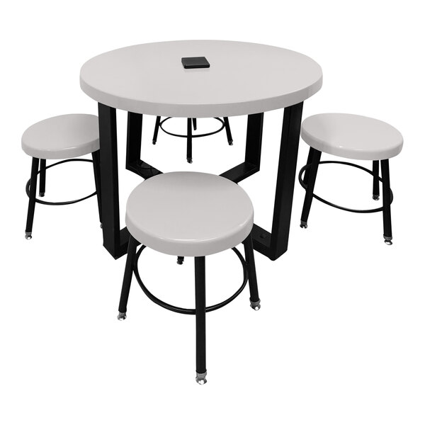 A white round Sol-O-Matic children's table with black legs and four white stools.