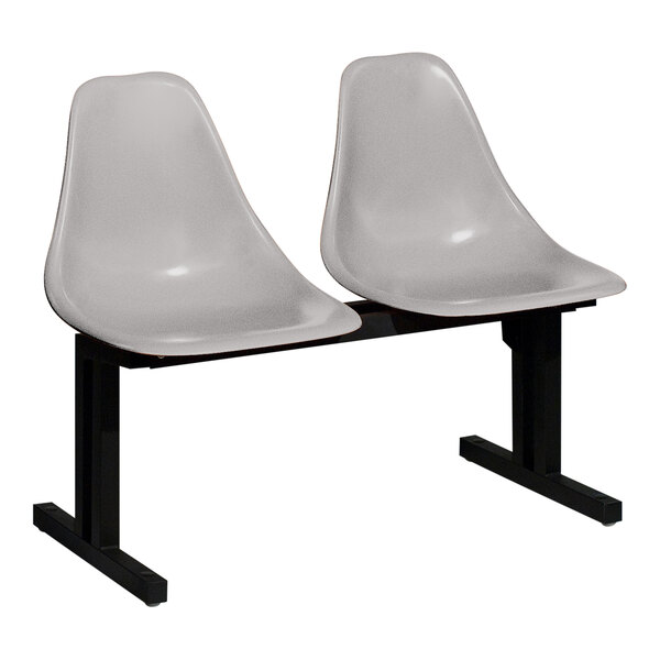 A Sol-O-Matic two-person modular seating unit with two white chairs on a black base.
