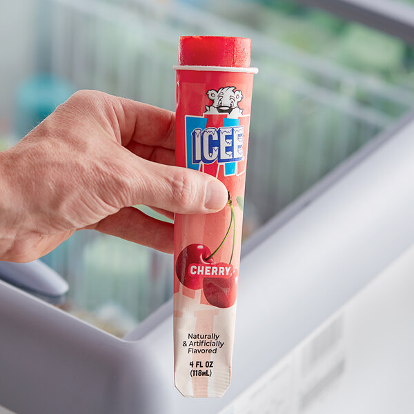 A hand holding an ICEE Cherry Freeze tube.