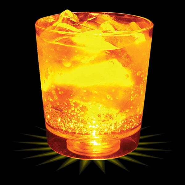 A 6 oz plastic rocks cup filled with yellow liquid and ice with a glowing yellow light.