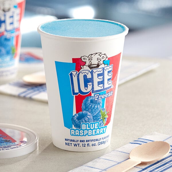 A case of ICEE Blue Raspberry Freeze cups on a table with a wooden spoon.