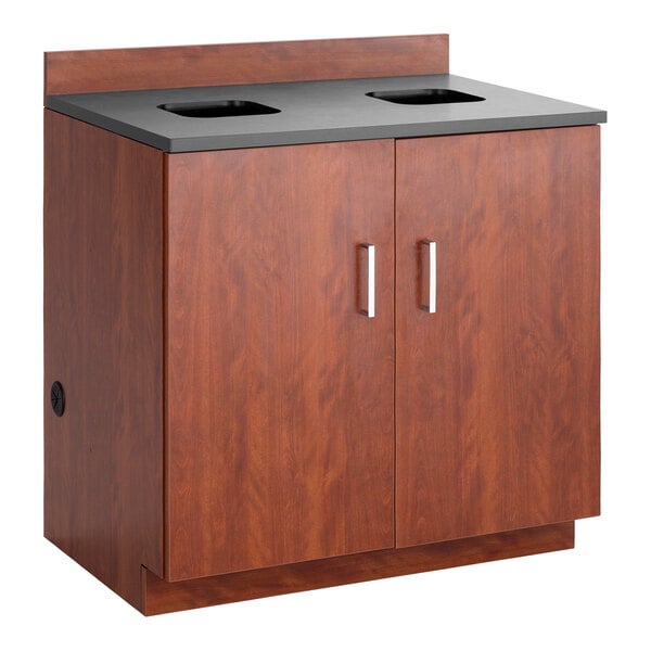 A mahogany Safco Hospitality base cabinet with a waste receptacle inside.