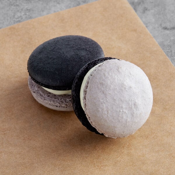 Two Macaron Centrale macarons with white and black icing.