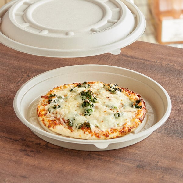 A pizza in a World Centric compostable pizza container on a table.