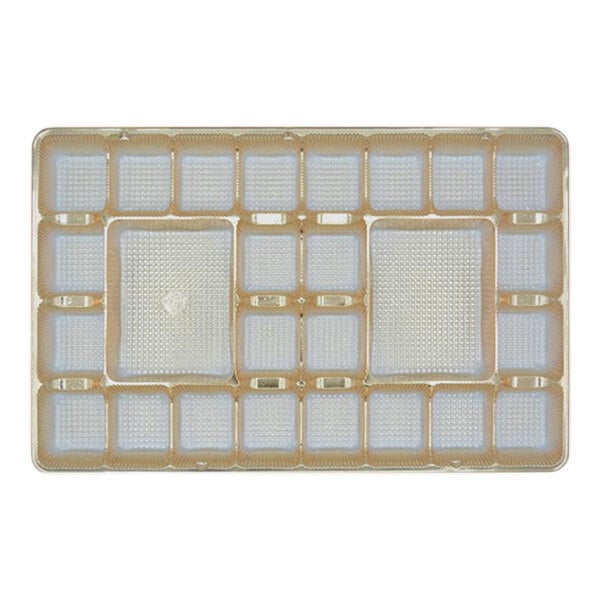 A gold tray with 26 square cavities.